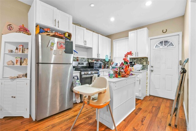 109-55 Lefferts Blvd, South Ozone Park, NY 11419 - kitchen with backsplash, light countertops, light wood finished floors, stainless steel appliances, and white cabinetry