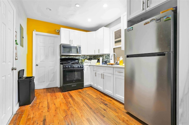 109-55 Lefferts Blvd, South Ozone Park, NY 11419 - kitchen with decorative backsplash, appliances with stainless steel finishes, white cabinets, and light countertops