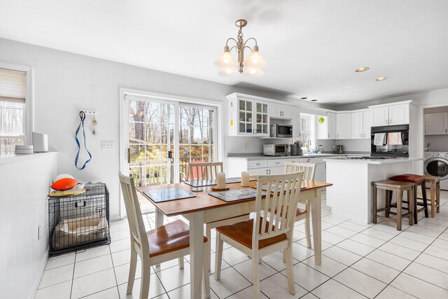 dining room with washer / clothes dryer, an inviting chandelier, and plenty of natural light