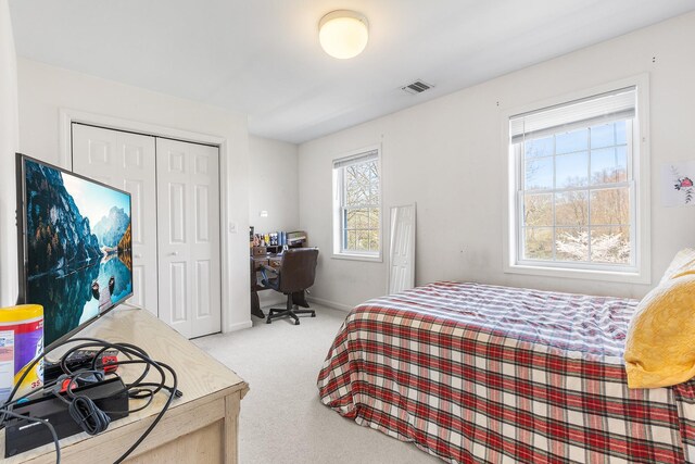 bedroom with baseboards, visible vents, carpet, and a closet