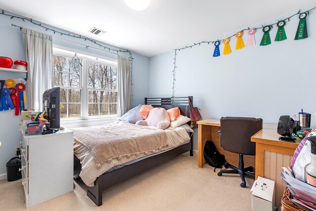bedroom with visible vents and light carpet