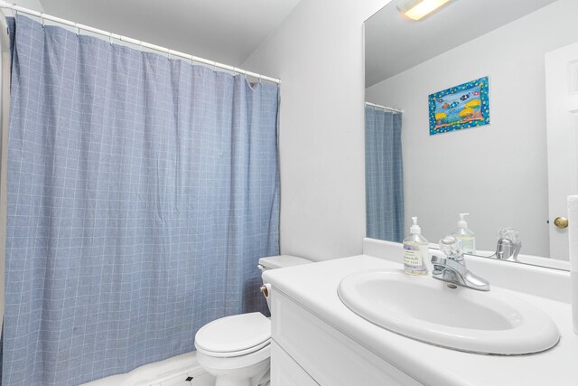 bathroom with toilet, a shower with shower curtain, and vanity