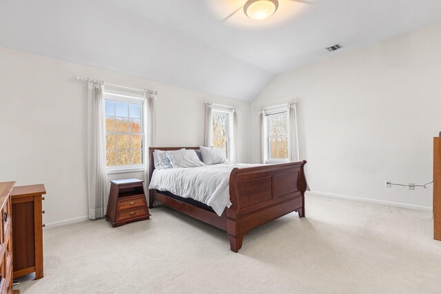 bedroom with baseboards, visible vents, light carpet, and vaulted ceiling