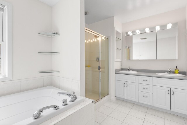 full bathroom featuring a garden tub, a sink, a stall shower, and double vanity