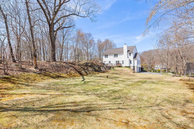 exterior space with a trampoline, a front yard, and a chimney