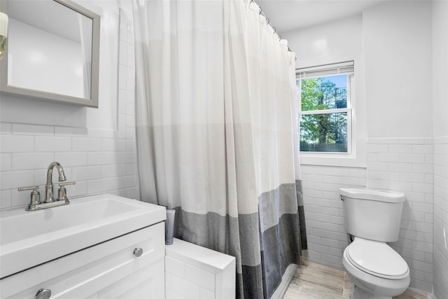 120 Loomis Ave, Yonkers, NY 10704 - bathroom featuring tile walls, toilet, a wainscoted wall, vanity, and curtained shower