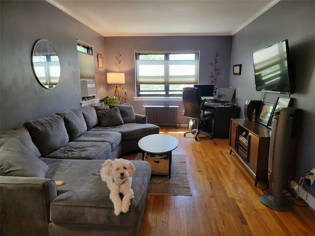 living area featuring light wood-type flooring, crown molding, and radiator heating unit