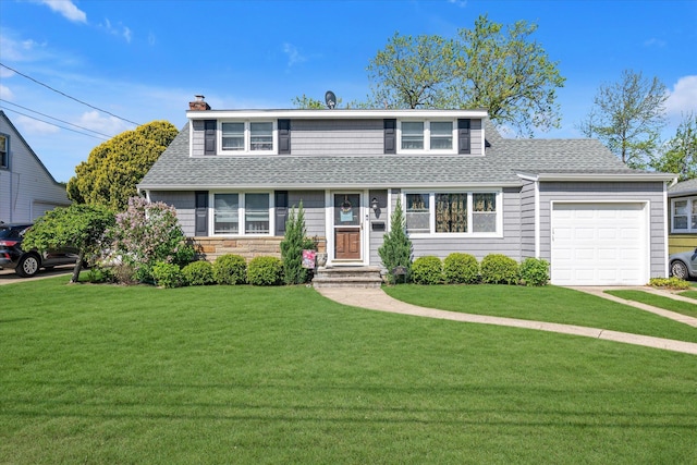 view of front of house with a shingled roof, an attached garage, and a front yard