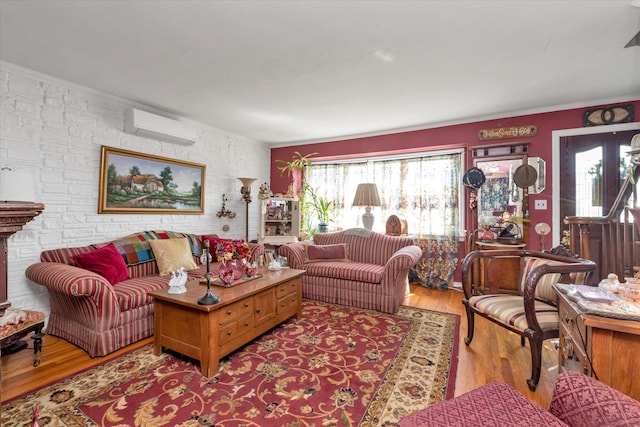 living area featuring an AC wall unit, wood finished floors, and crown molding
