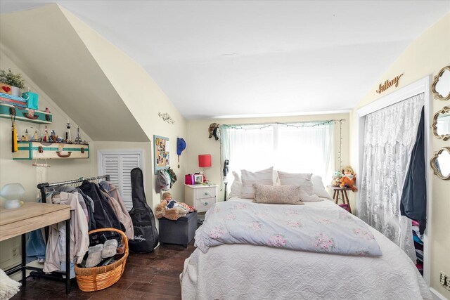 bedroom with vaulted ceiling and wood finished floors