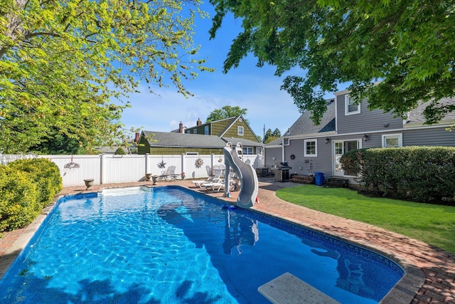 view of swimming pool with a water slide, entry steps, a grill, and a patio area