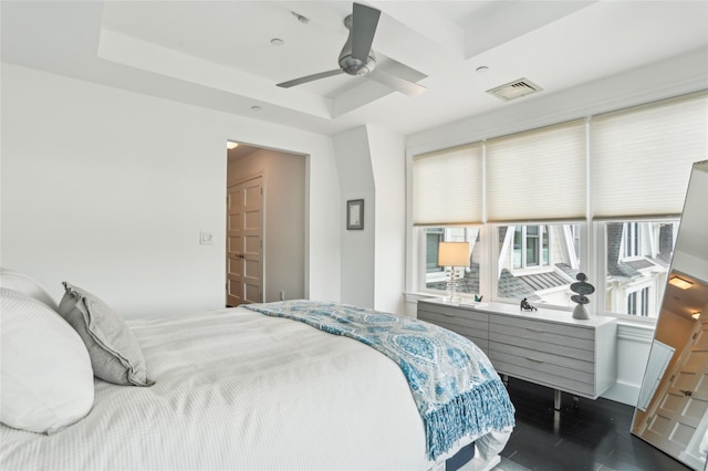 bedroom with dark wood-style flooring, ceiling fan, and visible vents