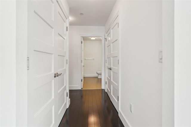 hall featuring baseboards and dark wood-style floors