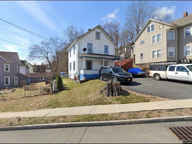 view of front of home with a residential view and a front lawn