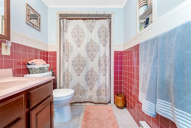 bathroom with tile walls, a wainscoted wall, and crown molding