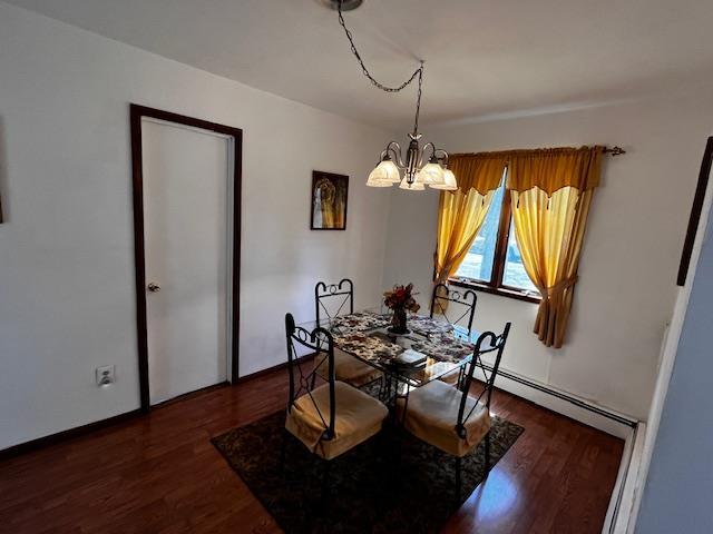 dining room with wood finished floors, a notable chandelier, and baseboard heating