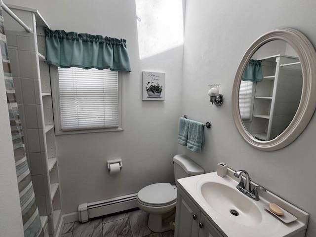 full bathroom featuring a shower with curtain, marble finish floor, baseboard heating, toilet, and vanity