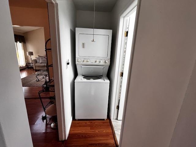 clothes washing area with stacked washer and dryer and wood finished floors