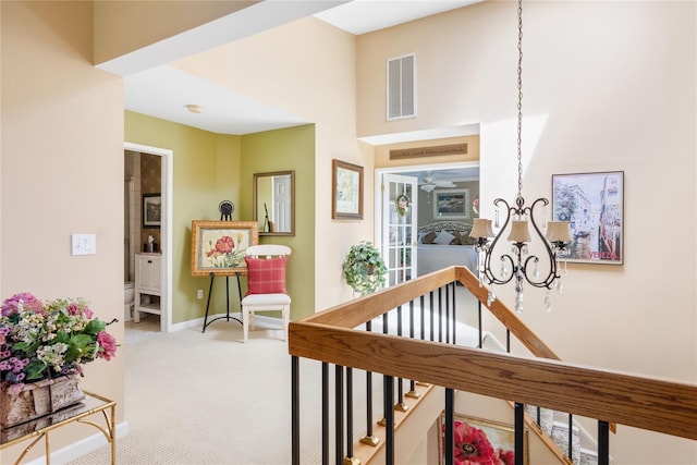 interior space with carpet flooring, baseboards, visible vents, and an inviting chandelier