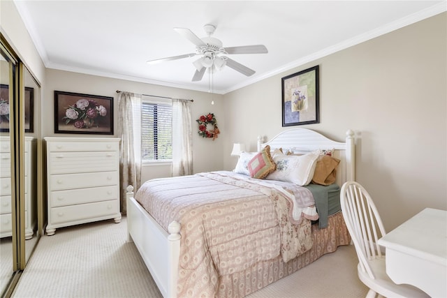 carpeted bedroom with ceiling fan, ornamental molding, and a closet