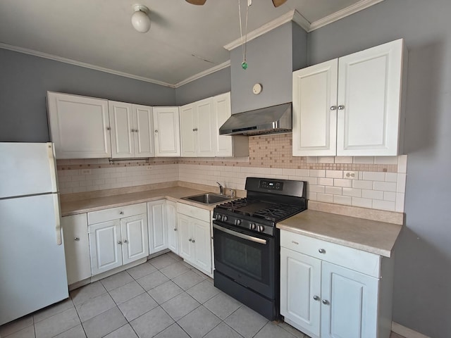 kitchen with wall chimney range hood, a sink, freestanding refrigerator, ornamental molding, and black gas range