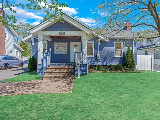 565 Baldwin Ave, North Baldwin, NY 11510 - view of front of property with covered porch, a chimney, and a front yard