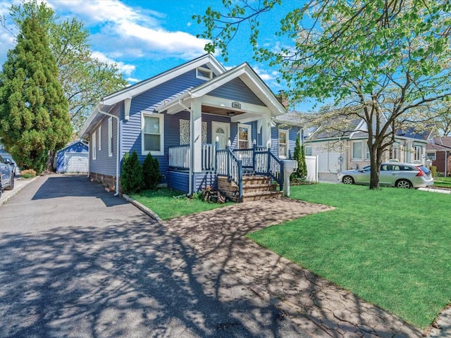 565 Baldwin Ave, North Baldwin, NY 11510 - view of front facade with a detached garage, an outbuilding, a porch, and a front yard