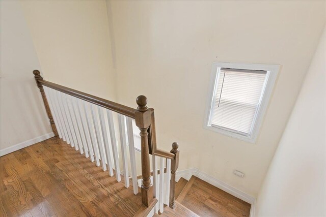 staircase with wood finished floors and baseboards