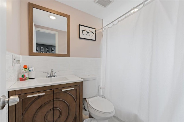 bathroom featuring visible vents, toilet, a shower with shower curtain, and vanity
