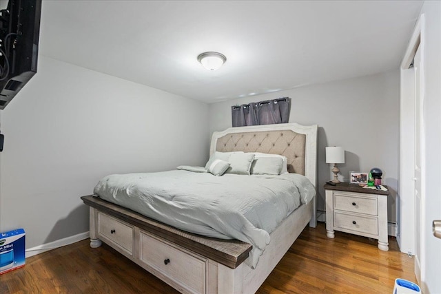 bedroom with wood finished floors and baseboards