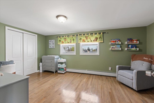 living area with a baseboard radiator and light wood-style floors