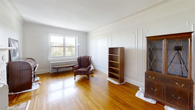 living area with light wood-style flooring and a decorative wall