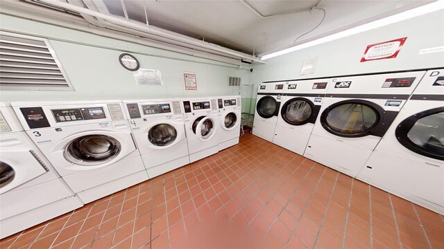 community laundry room with tile patterned flooring, visible vents, and washing machine and clothes dryer