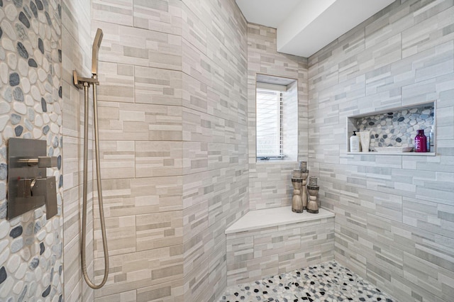 full bath featuring tile walls and tiled shower