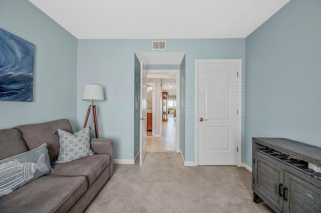 living room with baseboards, light carpet, and visible vents
