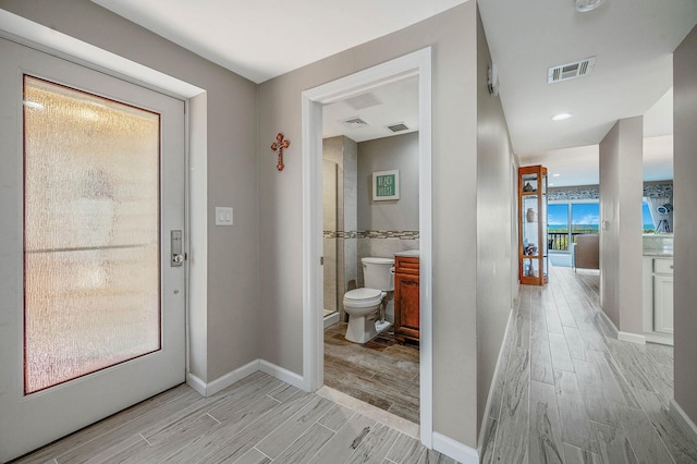 interior space with baseboards, visible vents, and wood tiled floor