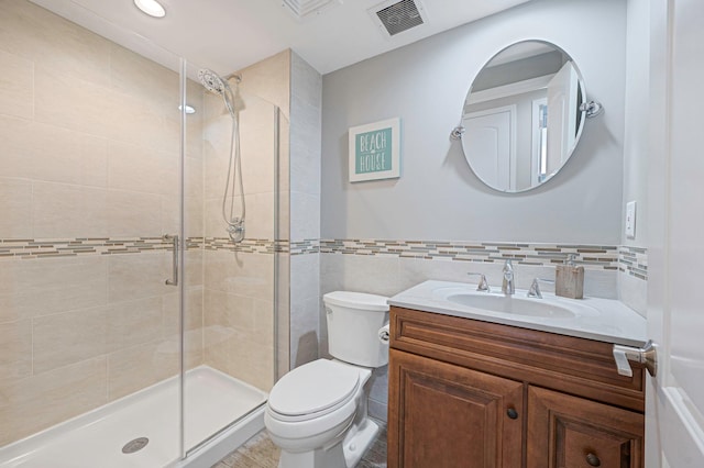 bathroom with visible vents, a stall shower, toilet, and tile walls