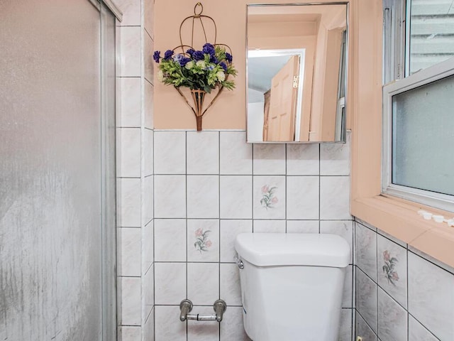 bathroom with tile walls and toilet