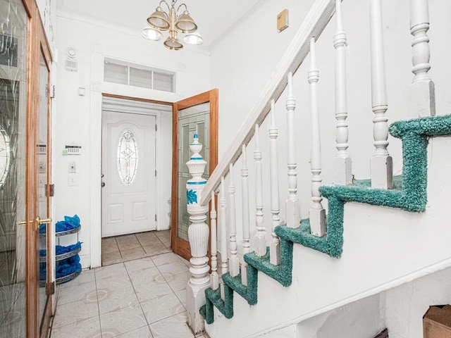 foyer featuring light tile patterned floors, an inviting chandelier, and stairs
