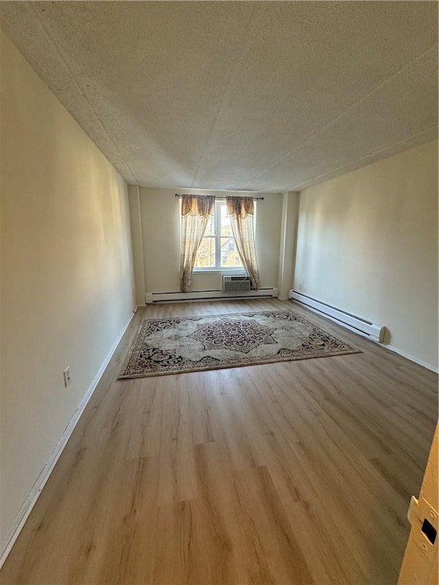 35 Park Ave Unit 1D, Suffern, NY 10901 - spare room with a textured ceiling, baseboards, a baseboard heating unit, and wood finished floors