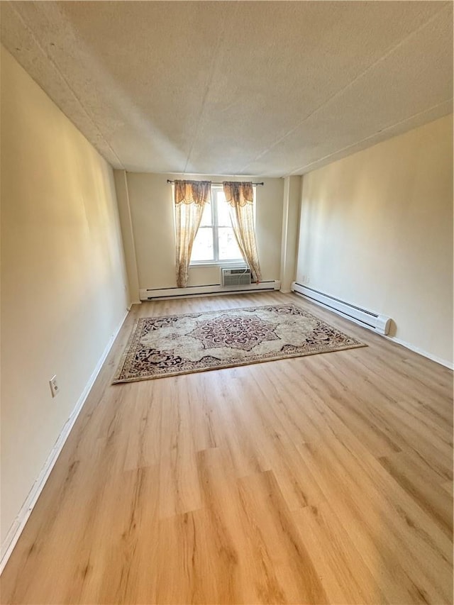 35 Park Ave Unit 1D, Suffern, NY 10901 - unfurnished dining area featuring a textured ceiling, baseboards, a baseboard heating unit, and wood finished floors