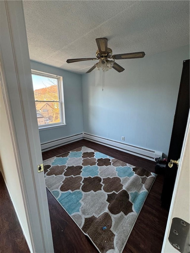 35 Park Ave Unit 1D, Suffern, NY 10901 - interior space with a ceiling fan, a textured ceiling, wood finished floors, baseboards, and a baseboard heating unit