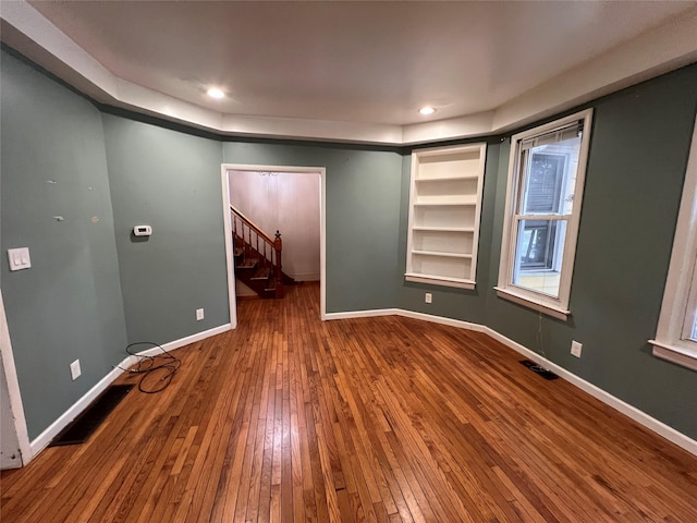 57 Prince St, Middletown, NY 10940 - spare room with visible vents, built in shelves, stairway, baseboards, and wood-type flooring