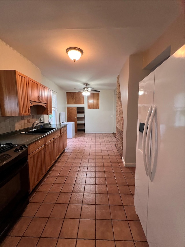 57 Prince St, Middletown, NY 10940 - kitchen with dark countertops, a sink, white fridge with ice dispenser, black range, and light tile patterned flooring