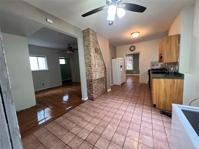 57 Prince St, Middletown, NY 10940 - kitchen with dark countertops, stove, ceiling fan, white refrigerator with ice dispenser, and light tile patterned floors