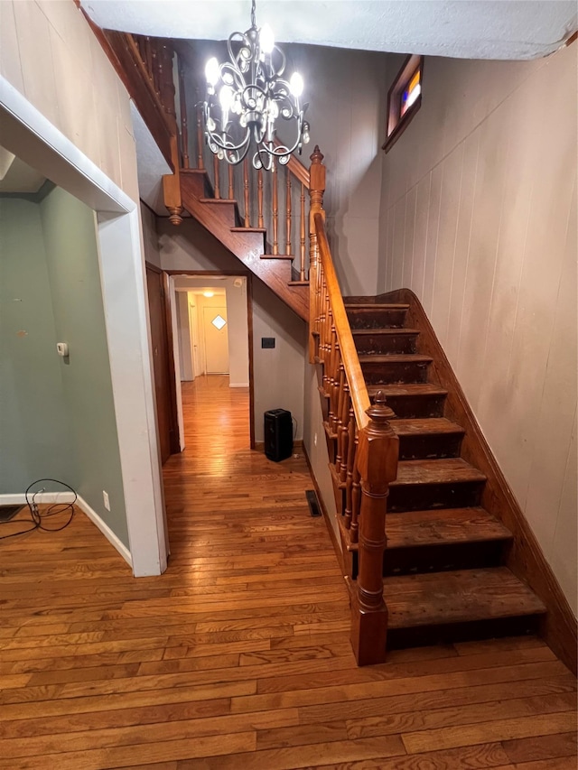 57 Prince St, Middletown, NY 10940 - stairway featuring visible vents, baseboards, a chandelier, and hardwood / wood-style floors