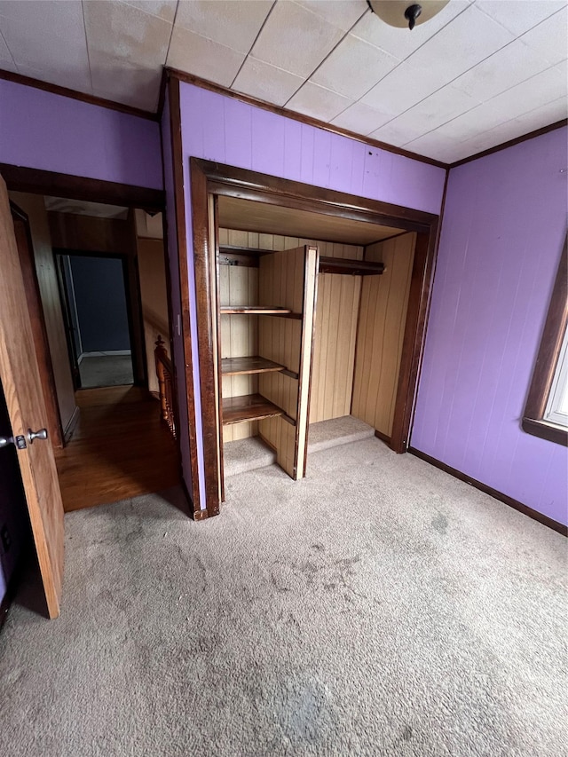 57 Prince St, Middletown, NY 10940 - unfurnished bedroom featuring baseboards, ornamental molding, wood walls, and light colored carpet
