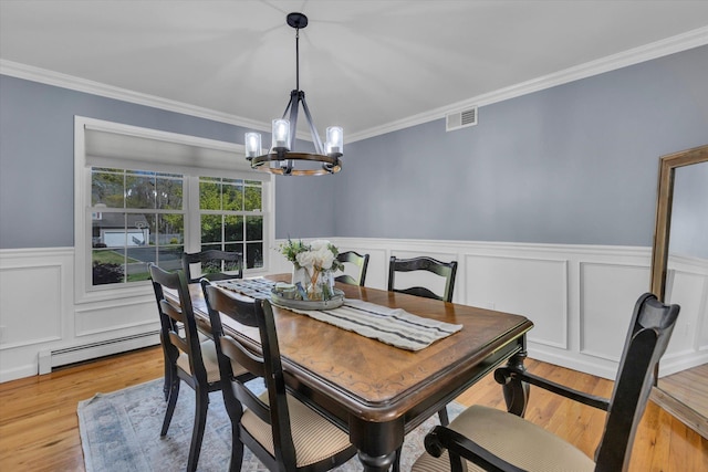 7 Karen Ct, Wading River, NY 11792 - dining area featuring visible vents, a wainscoted wall, an inviting chandelier, ornamental molding, and light wood-style flooring