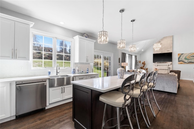 kitchen featuring stainless steel dishwasher, an inviting chandelier, a breakfast bar, dark wood-style floors, and open floor plan