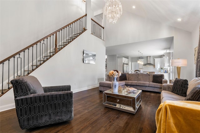living area with a high ceiling, an inviting chandelier, and wood finished floors